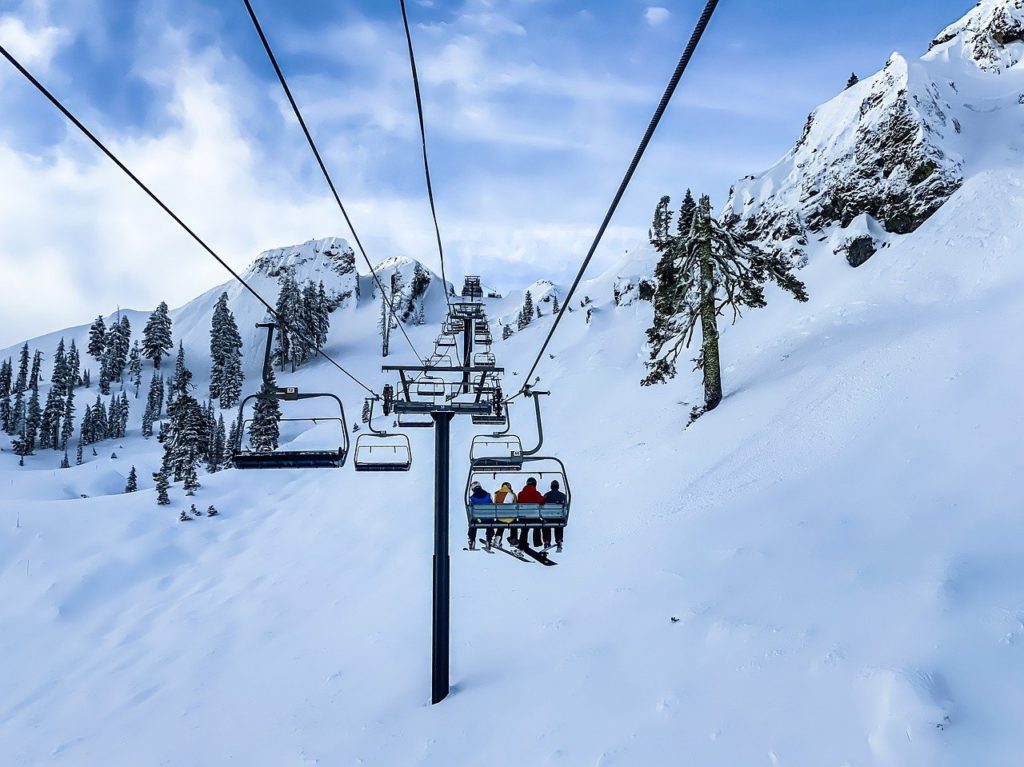 Skiers on chairlift in snow